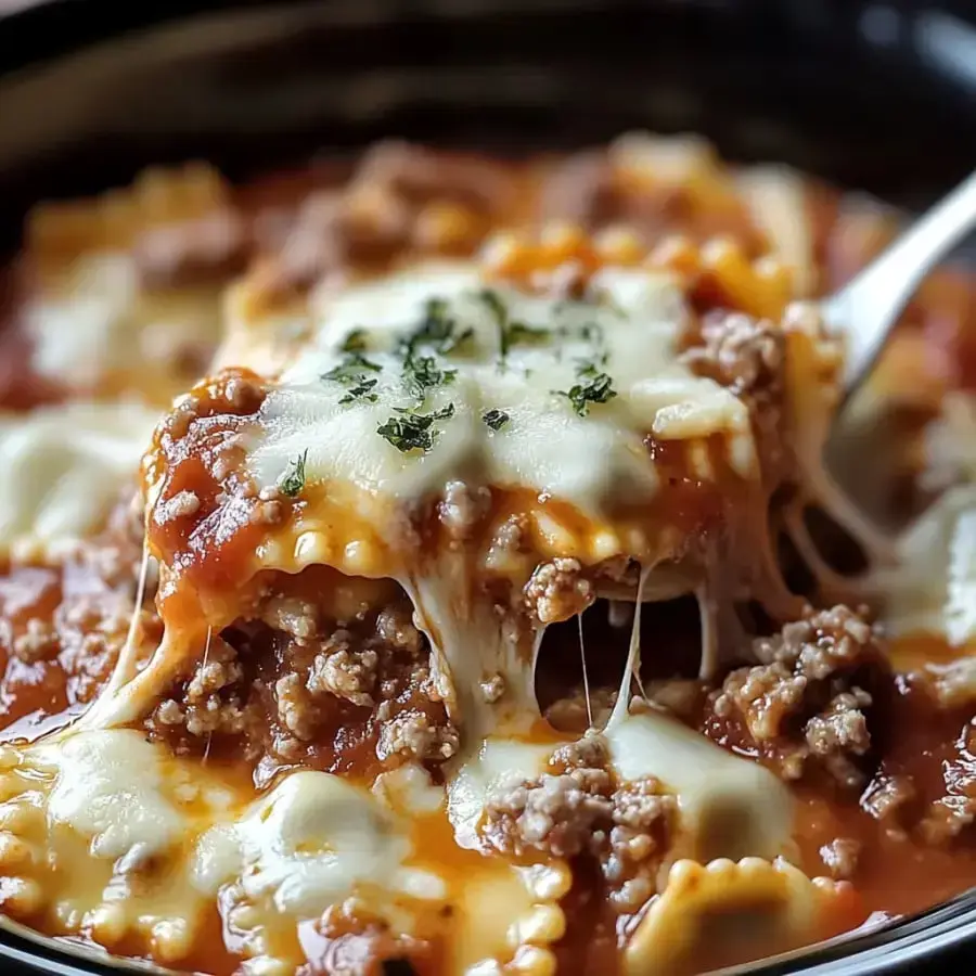 A close-up of cheesy lasagna topped with ground meat and garnished with parsley in a bowl.